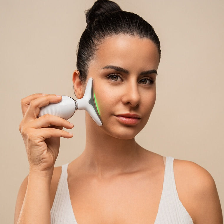 Mulher a usar o massajador facial Lumipel com luz LED no rosto